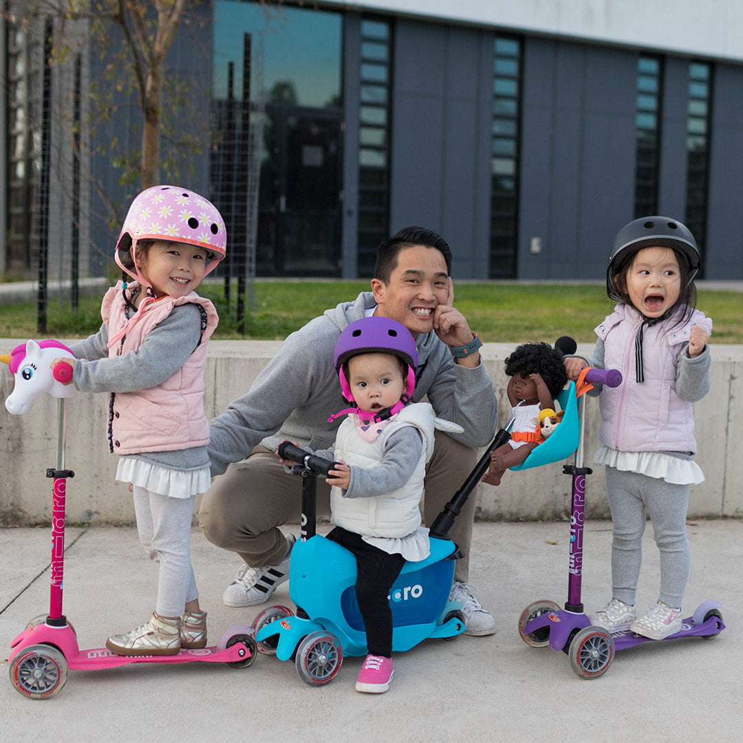 dad with his children riding 3 wheel scooters