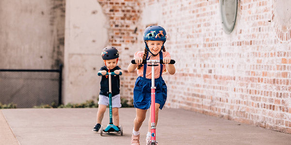 brother and sister on kids scooters