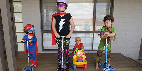 Kids dress up as scooting super heroes 