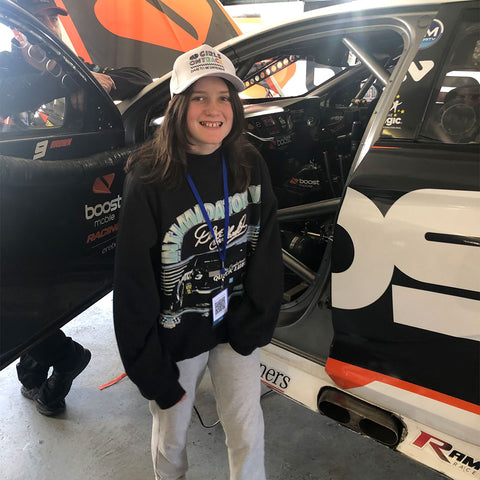 Seren Hughes standing in front of V8 rally car