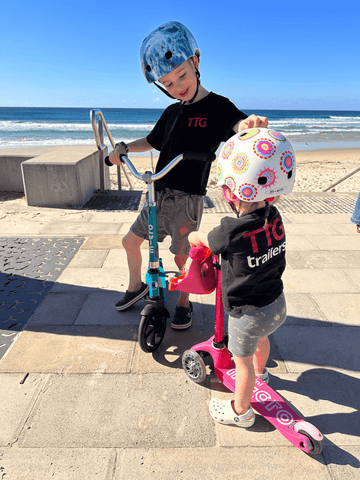 Jakey and Mia riding their Micro Scooters at the beach