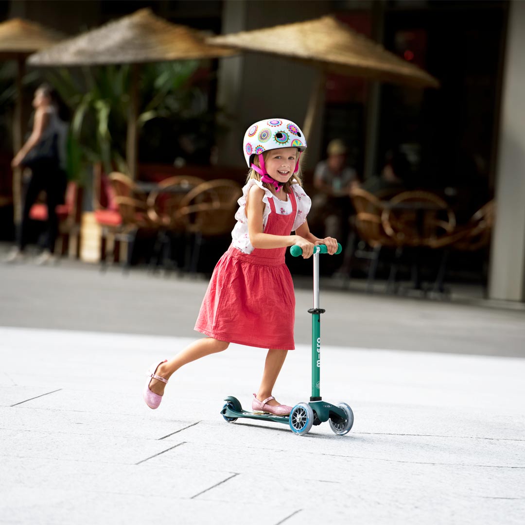young girl scooting on her deep green eco toddler scooter