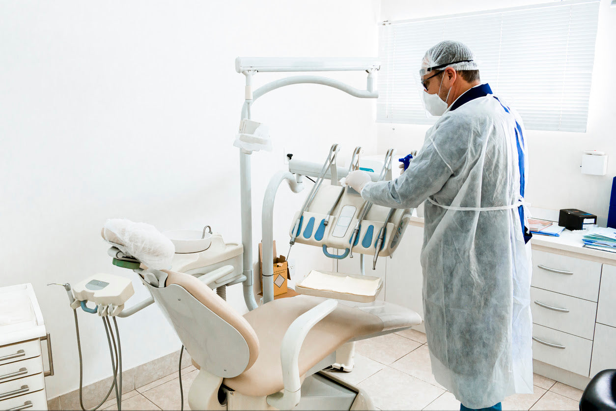 Dentist-with-wearing-protective-equipment-cleaning-and-disinfecting-the-equipment
