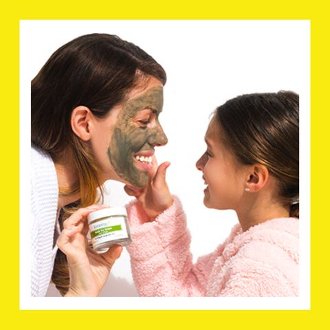 woman wearing face mask with girl touching her face