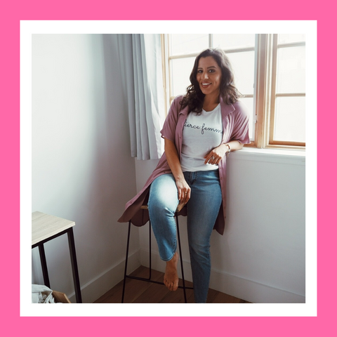 Woman a leaning against a wall semi sitting on a stool