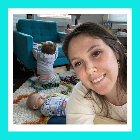 Woman on the floor with her two sons in the background playing