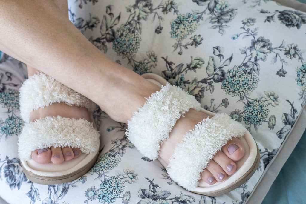 Chenille Parker 2-Band Slide Slippers on figure sitting on a pillow