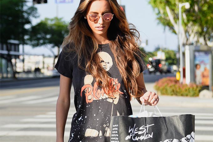 Women holding West of Camden bag and crossing the street