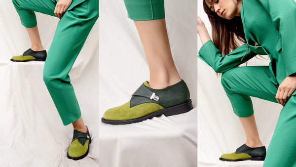 Woman in green suite wearing shoes in green suede and soft leather featuring side monk strap with buckle