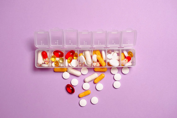 A container of various vitamins, supplements, and pills