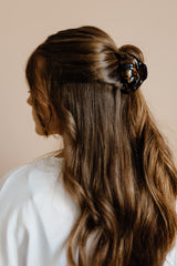 Femme aux cheveux longs et épais coiffée avec un pince à cheveux 