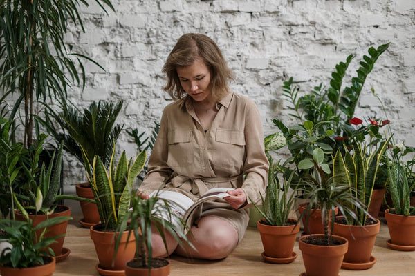 a girl sitting surrounded by plants