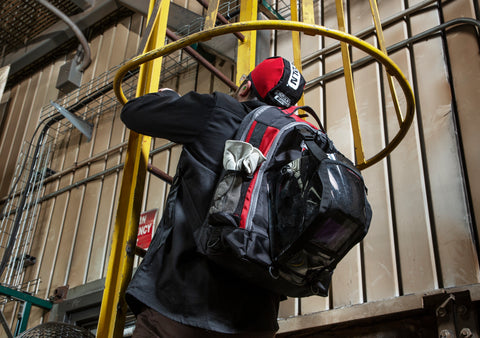 Worker carrying equipment in bag