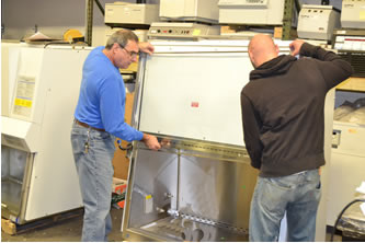 Techs reassembling a biosafety cabinet