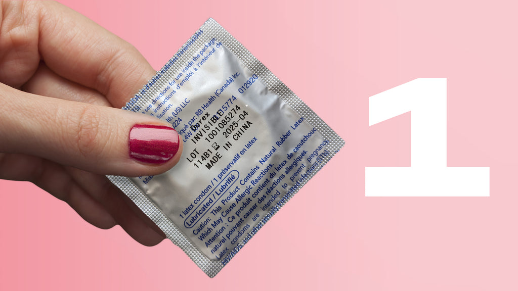 A hand holding a condom in a wrapper beside the number 1 in white text on a pink background.