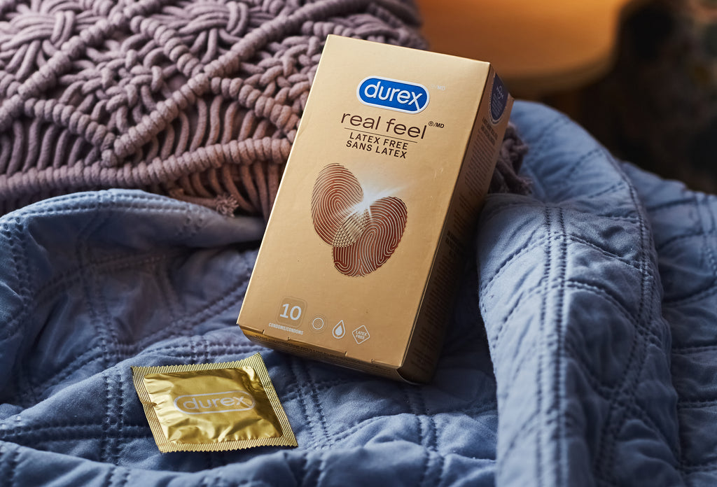 Les condoms Durex Real Feel reposent au milieu des draps, prêts pour les utilisateurs de condoms sans latex.