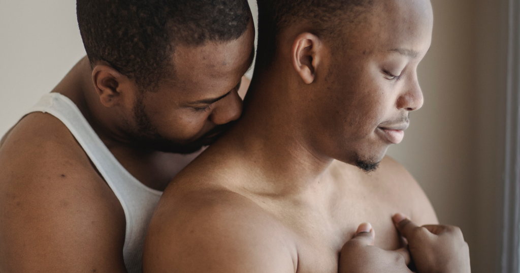 Deux hommes partageant un moment intime dans la lumière du soleil.