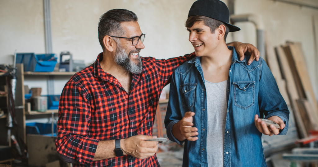 Father and son laughing together after having a sexual health conversation.