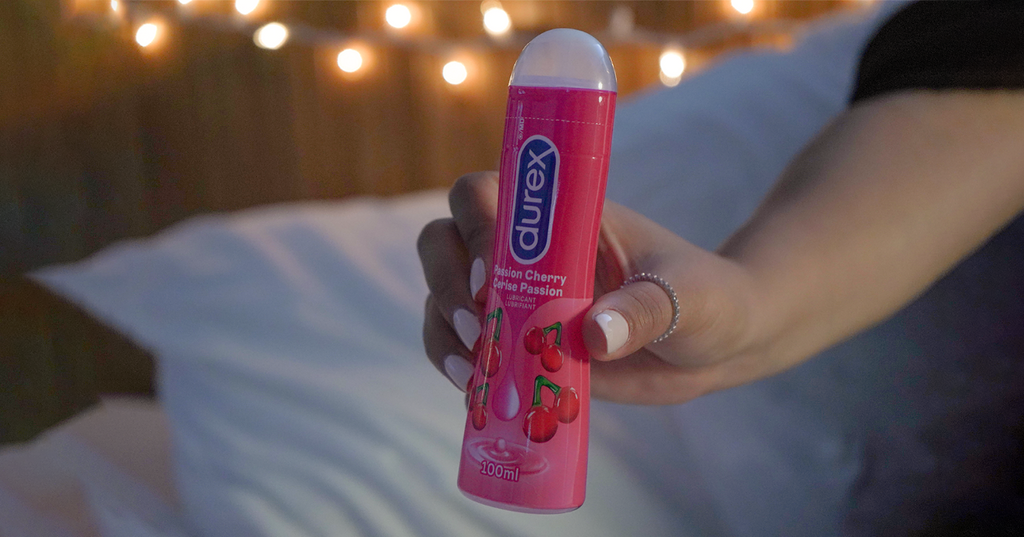 Person holding out Durex Passion Cherry Lubricant for a lubricated handjob.