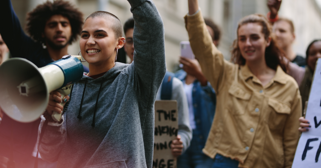 Various people raising their hands in unison at a sex movement protest.