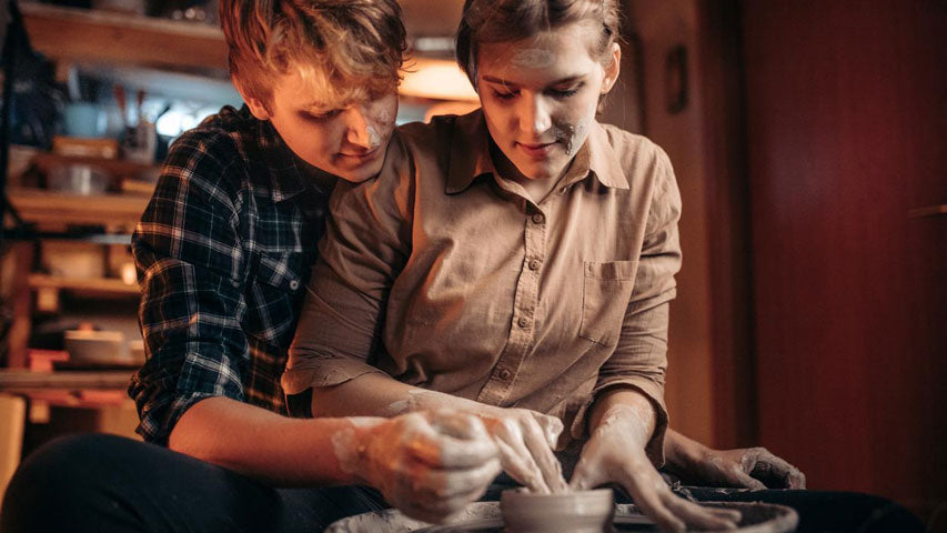 Un couple qui fabrique un petit bol ensemble pendant un cours de poterie.