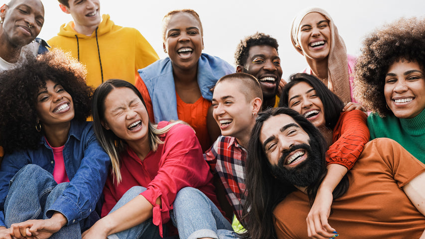 Multiple people smiling and wearing bright clothing in a symbol of togetherness.