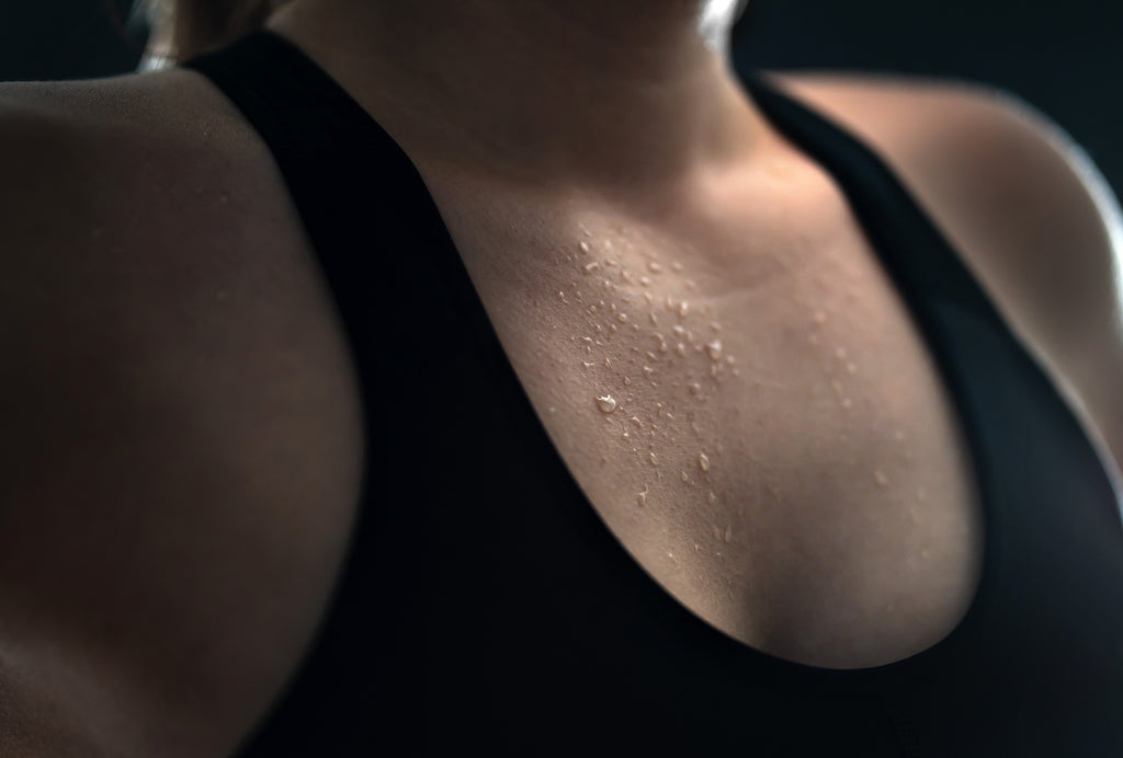 A woman's chest with sweat droplets.