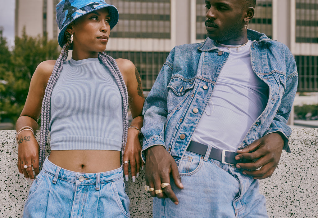 A man and woman stand beside each other outside and make eye contact.