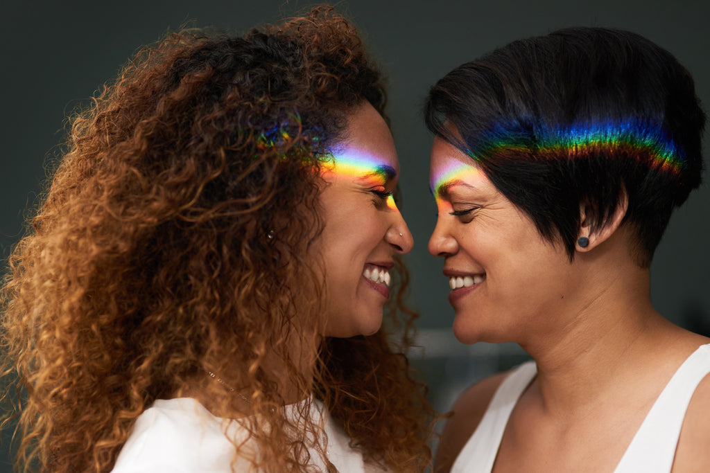 Two women exchange smiles as they get closer to one another.