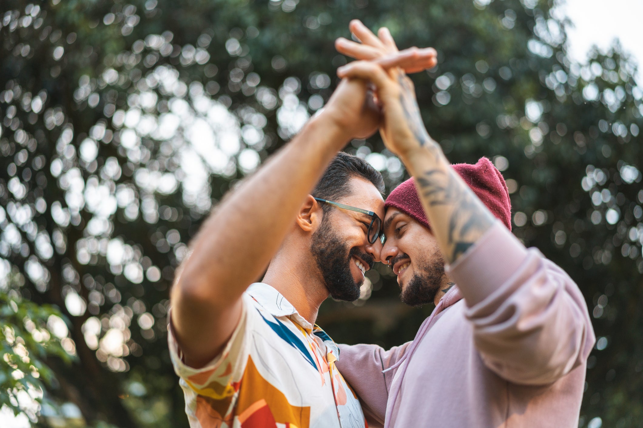 Un couple enlacé à l’extérieur qui se tient par la main.