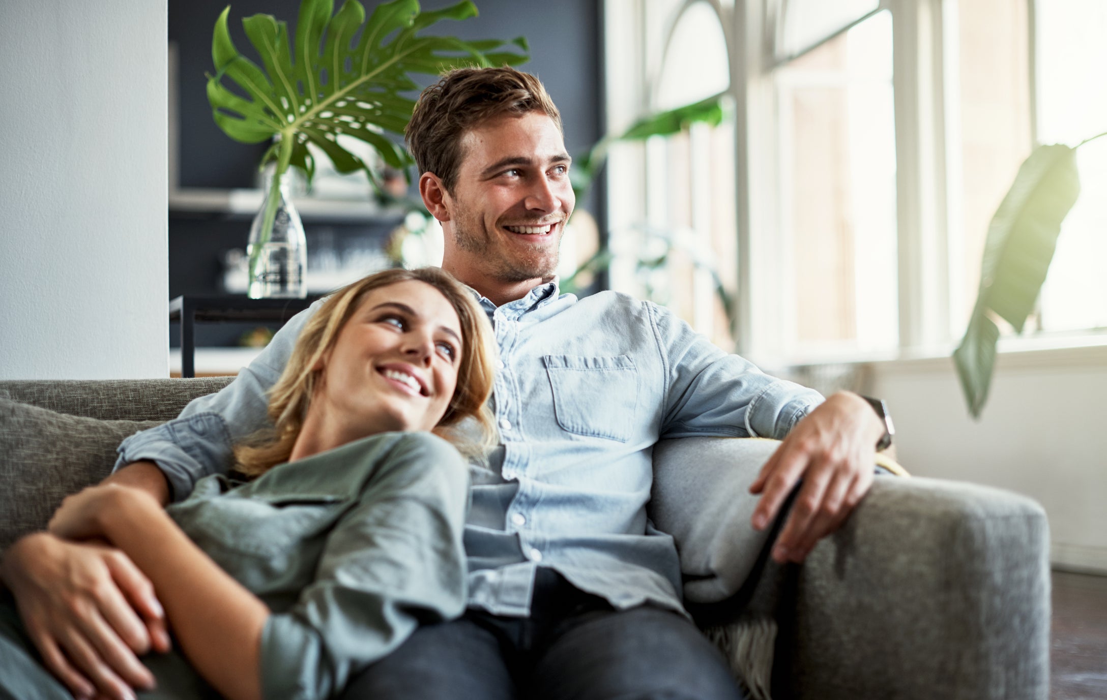 Un couple heureux qui s’étreint sur un canapé.