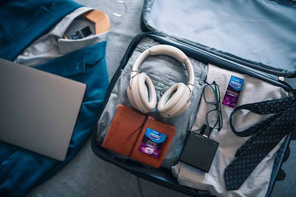 Une valise ouverte dans laquelle se trouvent un anneau pénien Durex Pleasure Ring et un vibromasseur Durex Intense dans leur emballage.