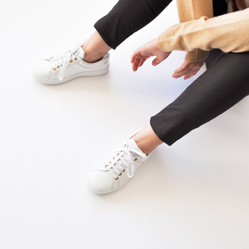 female seated down with feet shod in white sneakers marshmallow small size shoes model from petitfour feeling good collection