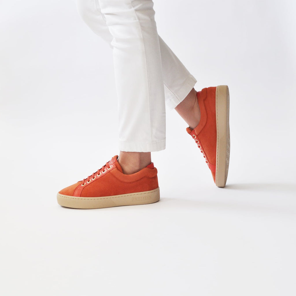 female walking with feet shod in orange sneakers papaya small size shoes model from petitfour feeling good collection