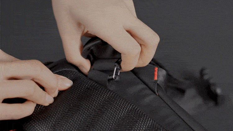 OneMo 2 Backpack Tutorial - To untie the buckle, press both sides of the buckle and push the metal ring down at the same time.