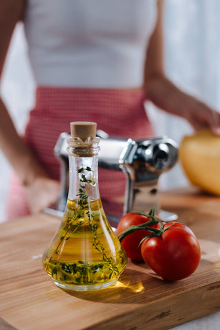 Bottle of olive oil next to fresh tomatoes.