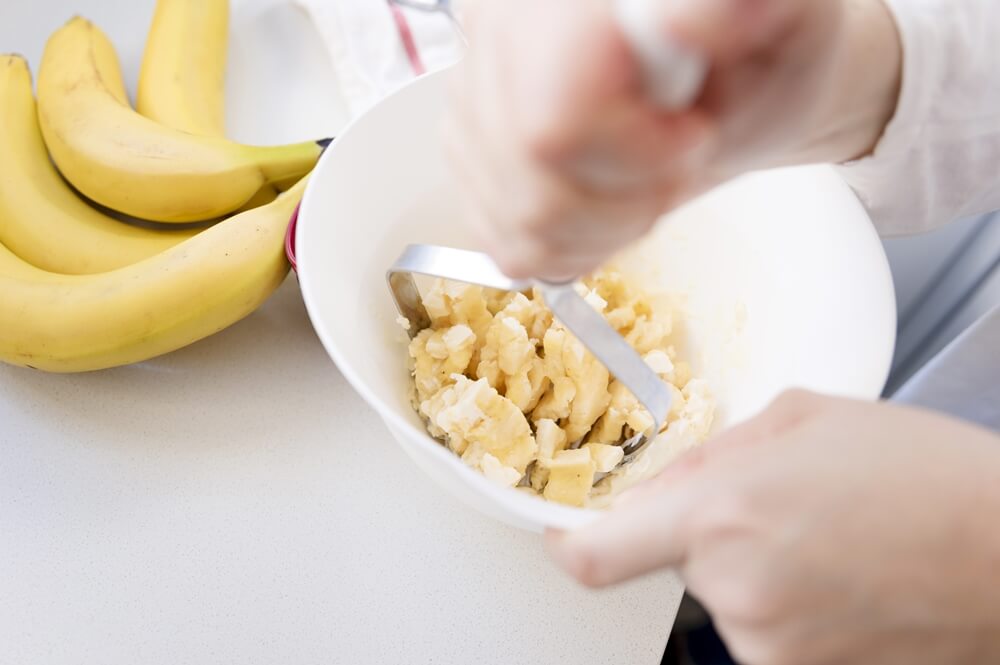 Careful hands prepare a healthy banana treat for a furry friend