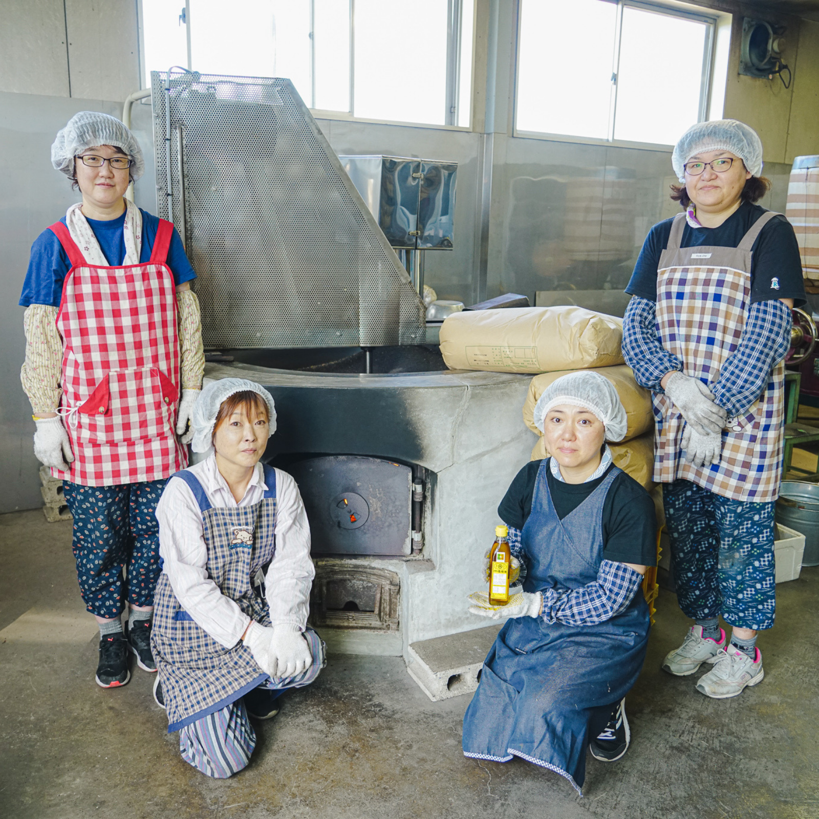 Four craftspeople standing in front of kettle