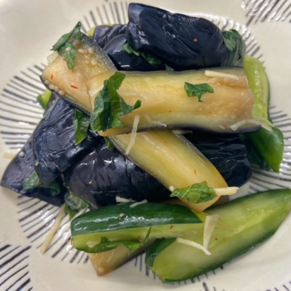 A plate of pickled egg plants and cucumbers