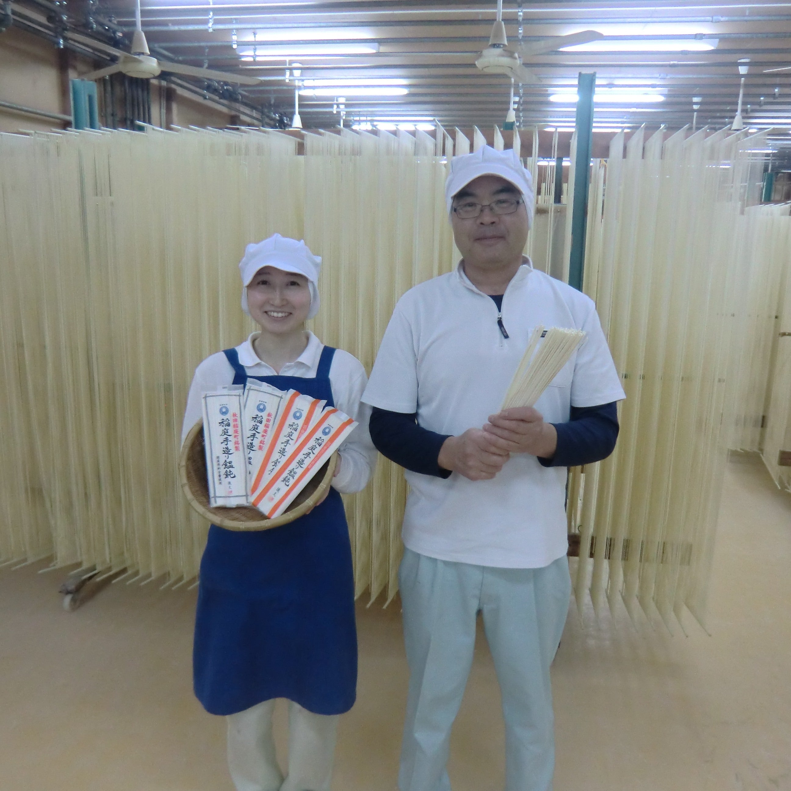 Two craftspeople holding noodles