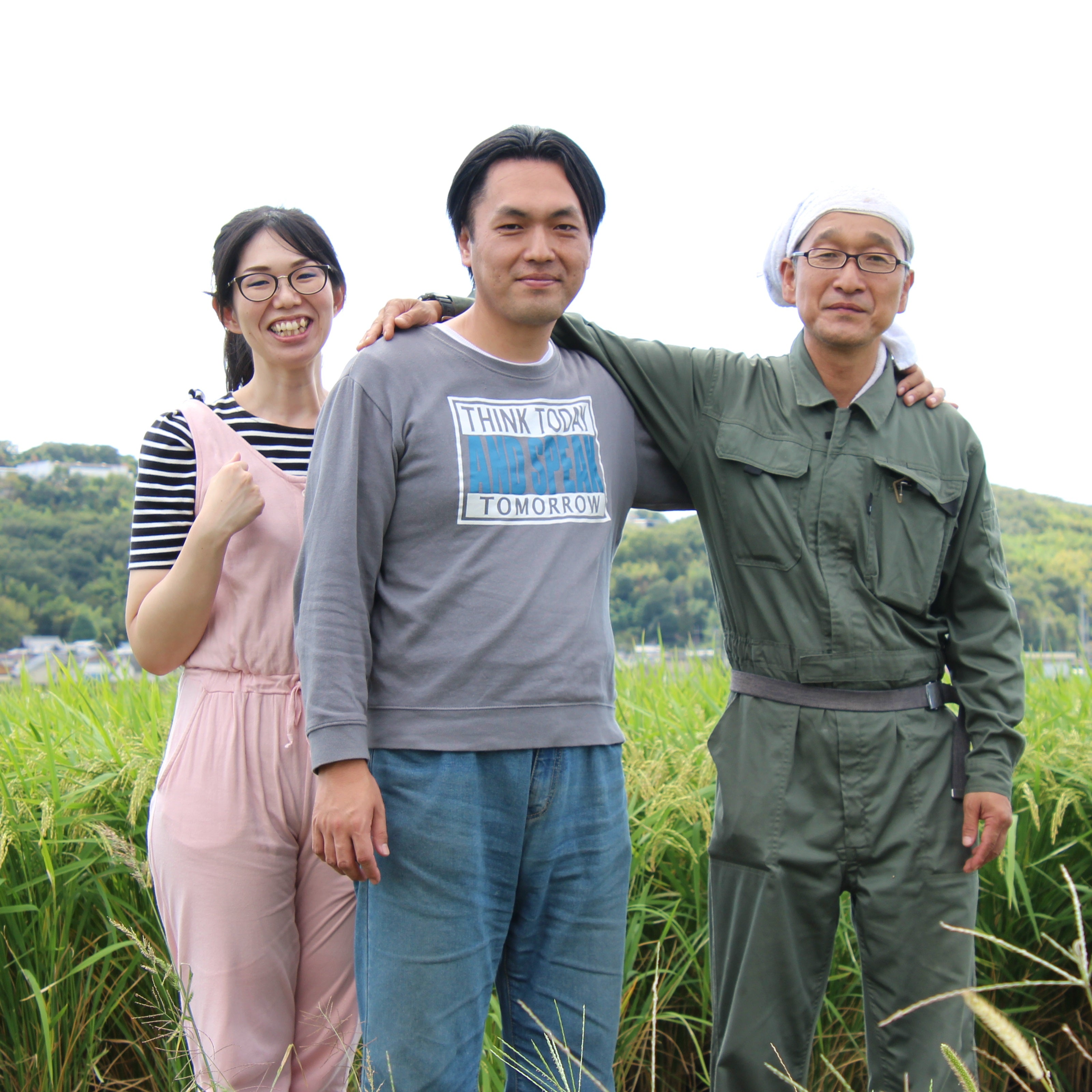 Three farmers standing in the middle of rice field