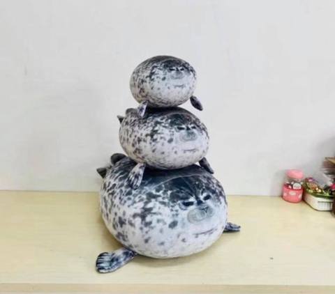 Three diffrent size chonky seal pillows, staked on top of each other