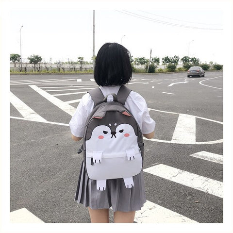 girl standing in street with back turned wearing a shiba shaped backpack