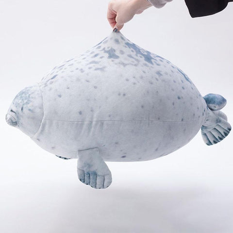 A person holding onto the fabric of a pillow in the shape of a seal