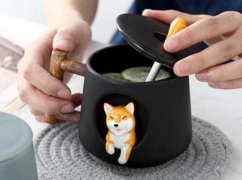 Shiba inu cup in black having its tea stirred with a spoon