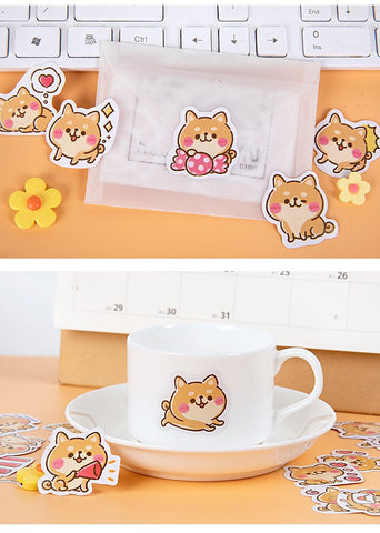 shiba world stickers on a cup and laptop