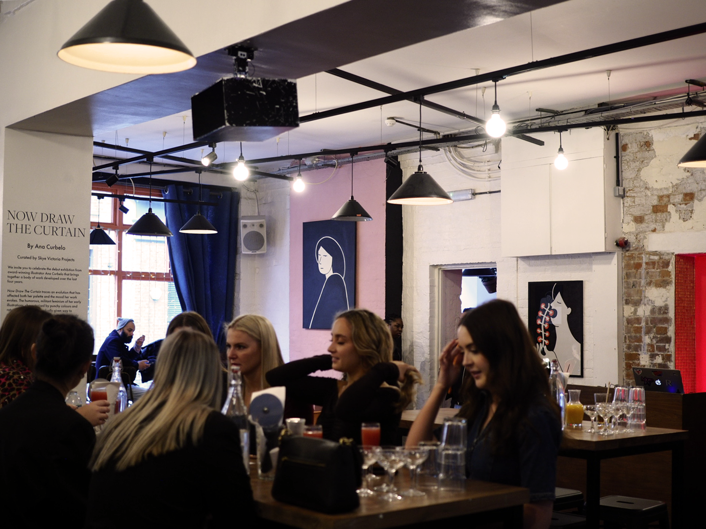 The Book Club bar with prints and oil paintings on the wall by artist Ana Curbelo