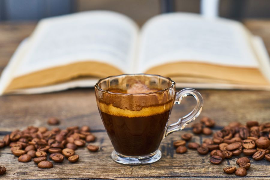 Coffee beans placed around a cup of Kona coffee