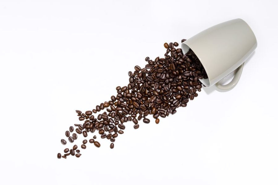 Coffee beans spilled out of a cup