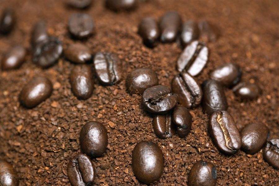 Coffee beans on top of ground coffee